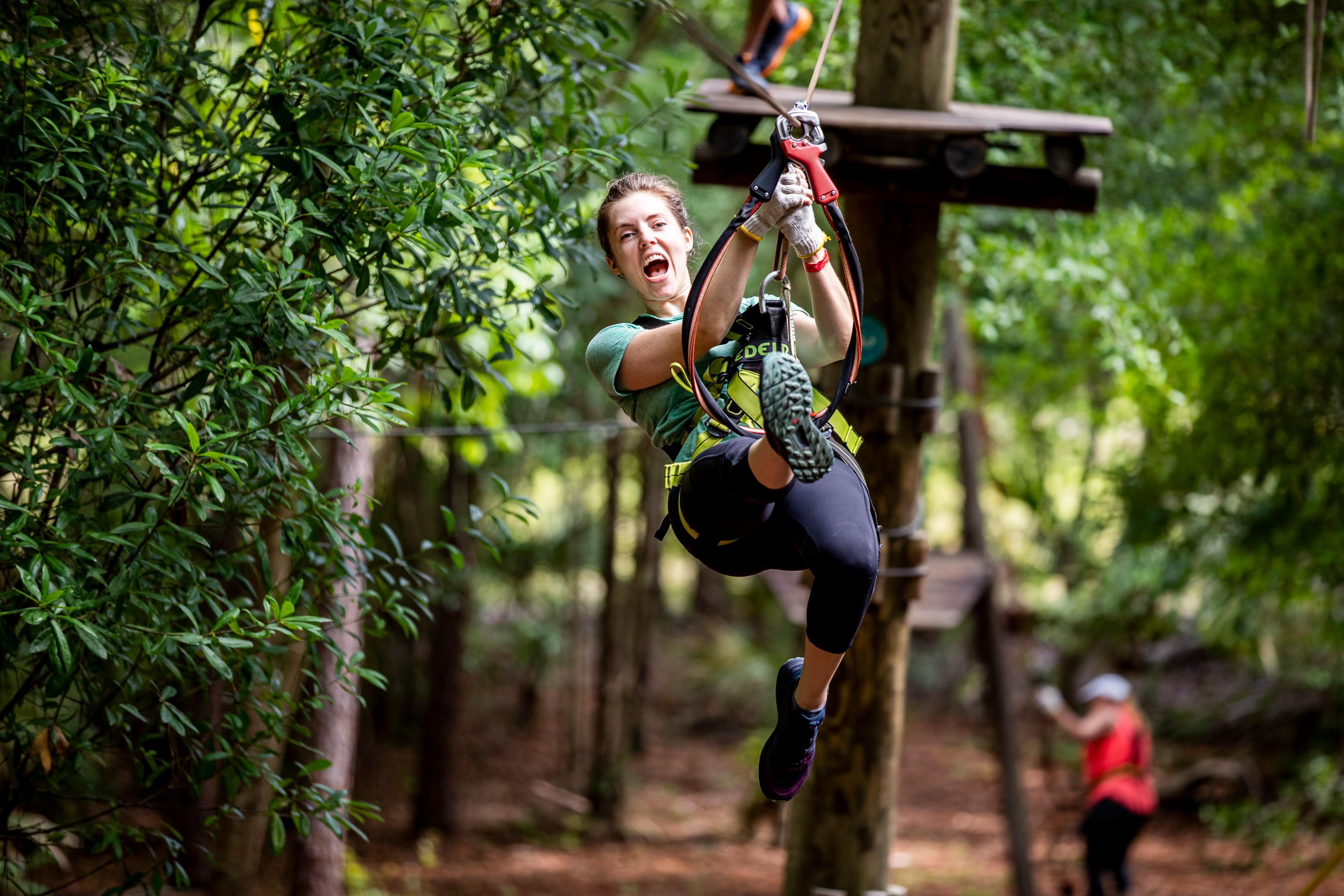 Person ziplining through a forest at Orlando Tree Trek